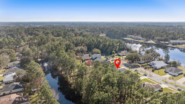 birds eye view of property with a water view and a wooded view