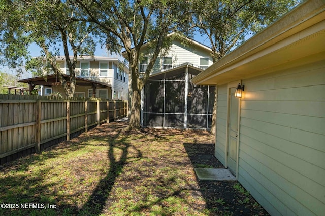 view of yard with a sunroom and fence