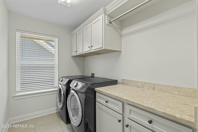 washroom featuring cabinet space, washer and clothes dryer, baseboards, and light tile patterned flooring