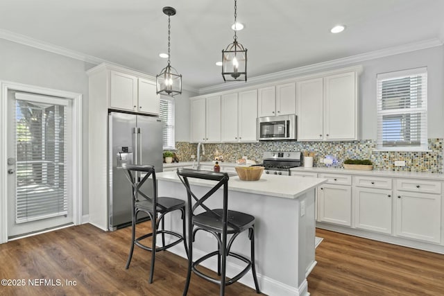 kitchen with stainless steel appliances, a center island, white cabinetry, and crown molding