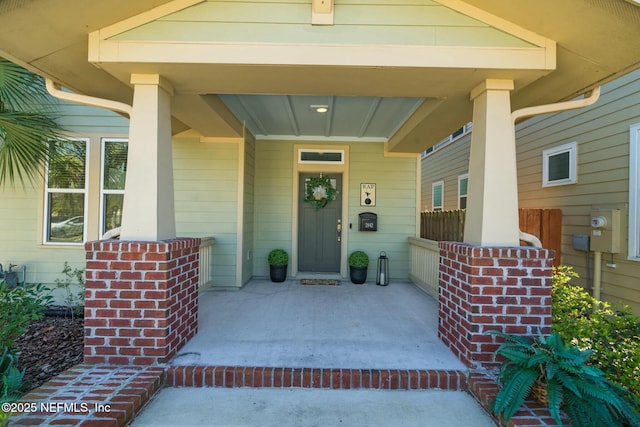 view of exterior entry featuring covered porch