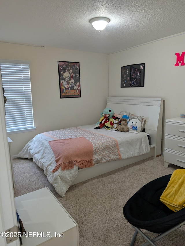 bedroom featuring a textured ceiling and carpet flooring