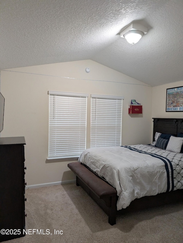 bedroom featuring light carpet, vaulted ceiling, a textured ceiling, and baseboards