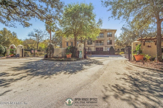 view of front of house featuring fence, a gate, and stucco siding