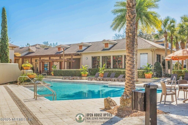 pool with a patio area and a pergola