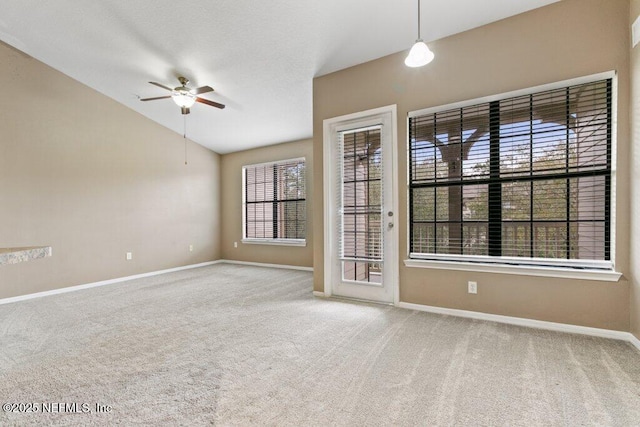 spare room featuring a ceiling fan, carpet, lofted ceiling, and baseboards