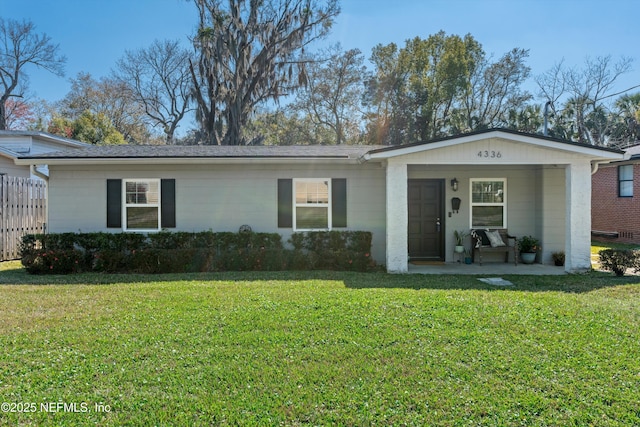 single story home with a front yard, covered porch, and fence