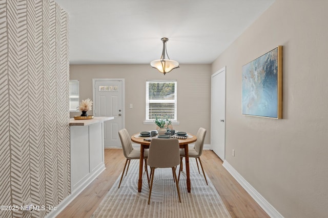 dining room featuring light wood-style floors and baseboards