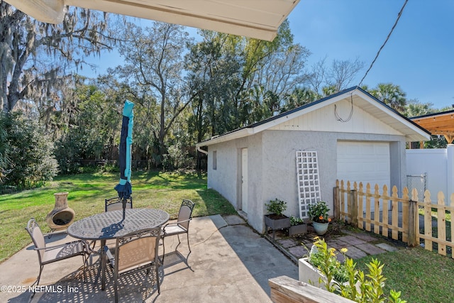 view of patio / terrace featuring outdoor dining space, fence, and an outdoor structure