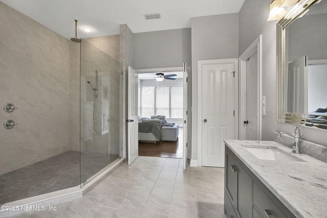 ensuite bathroom featuring visible vents, ceiling fan, ensuite bathroom, walk in shower, and vanity