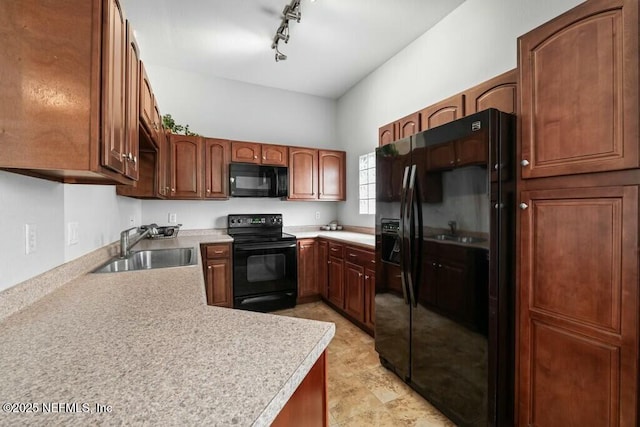 kitchen featuring black appliances, light countertops, a sink, and rail lighting