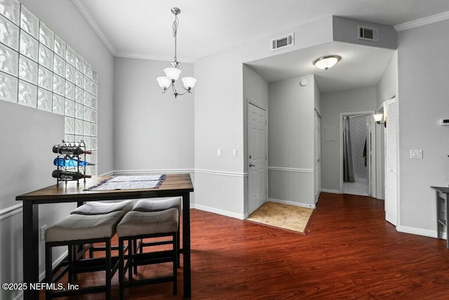 dining area with baseboards, a notable chandelier, visible vents, and wood finished floors