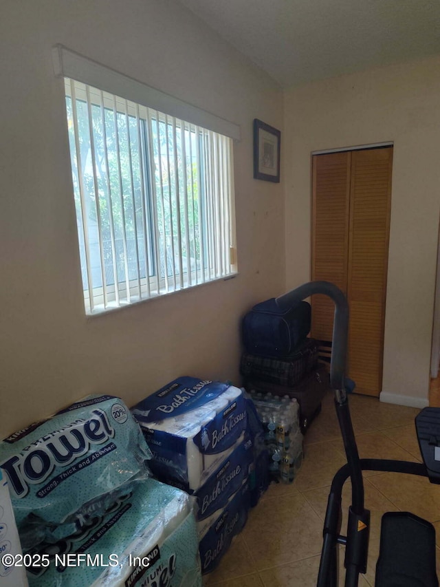 bedroom with tile patterned flooring and a closet