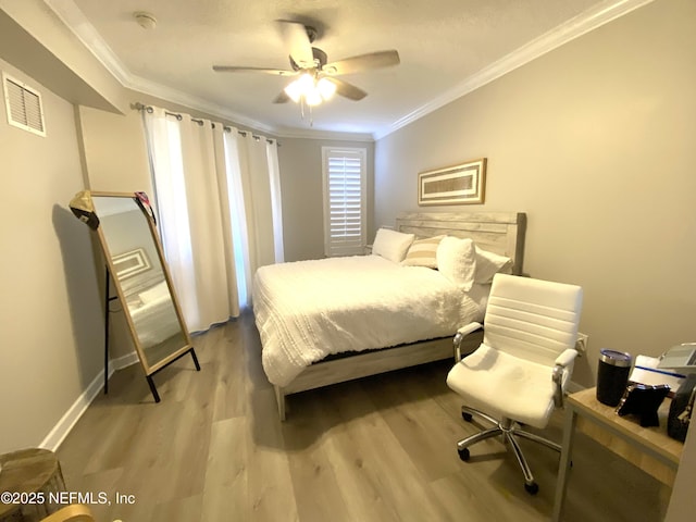 bedroom with visible vents, crown molding, light wood-style flooring, and ceiling fan