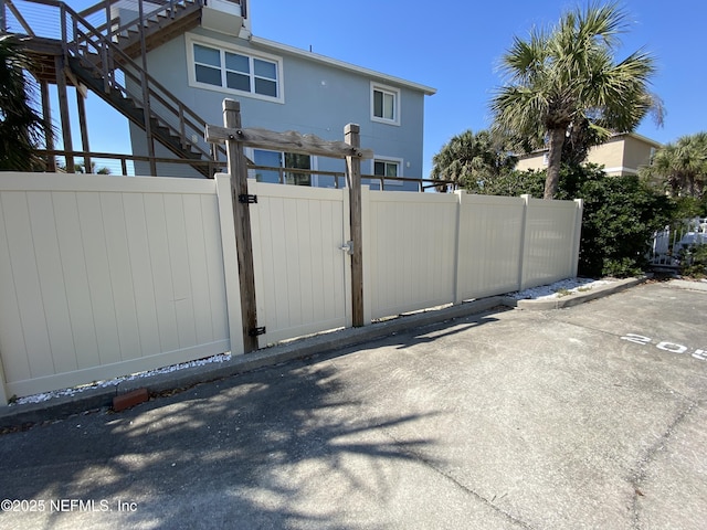 view of gate with stairs and fence