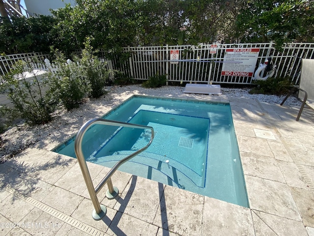 view of pool with a hot tub and fence