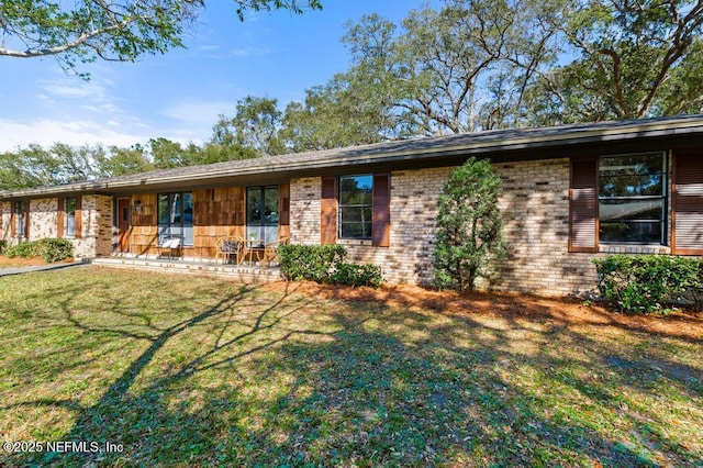 single story home featuring a front yard and brick siding