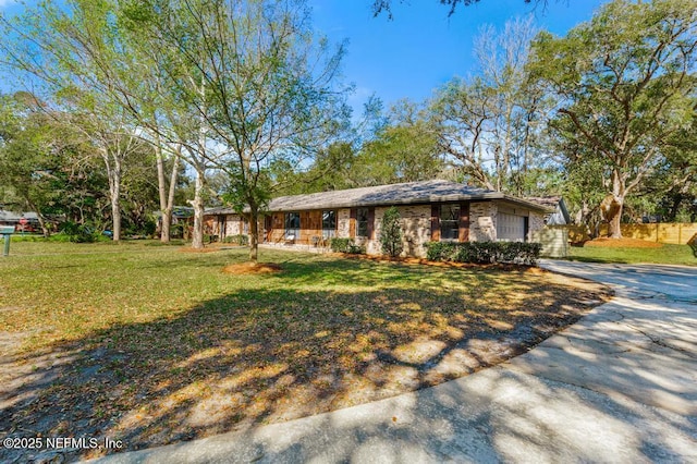 view of front of property with driveway, brick siding, and a front yard