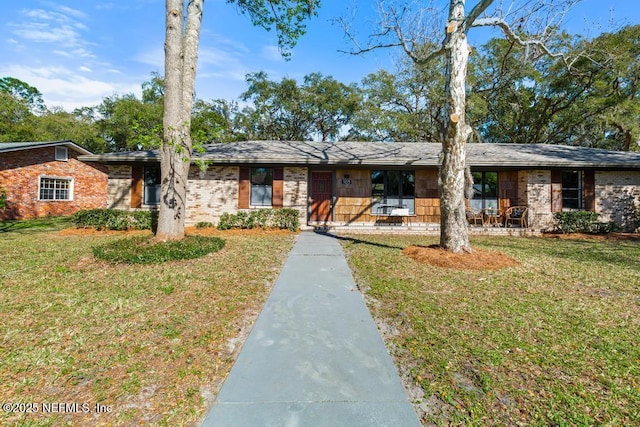 view of front facade with brick siding and a front lawn