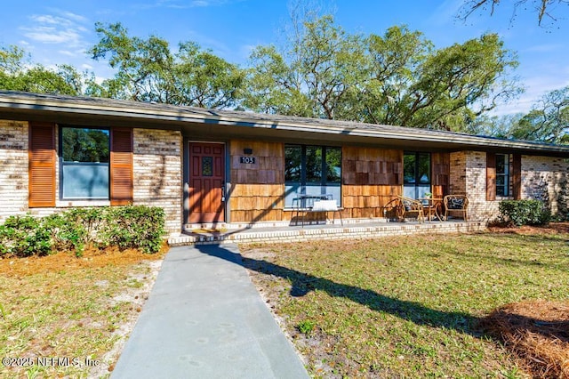 view of front of property with a front lawn and brick siding