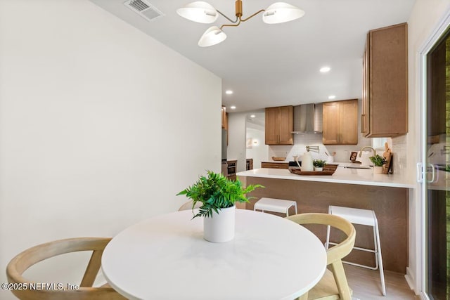 dining room with light wood-type flooring, visible vents, a notable chandelier, and recessed lighting