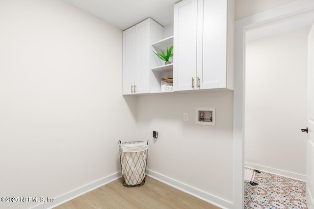 laundry room with cabinet space, light wood-style flooring, hookup for a washing machine, and baseboards