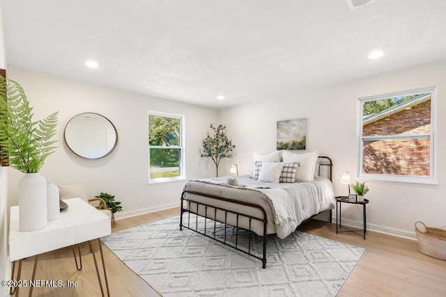 bedroom with light wood-style floors, baseboards, and recessed lighting