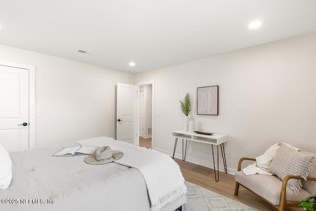 bedroom with recessed lighting, visible vents, baseboards, and wood finished floors