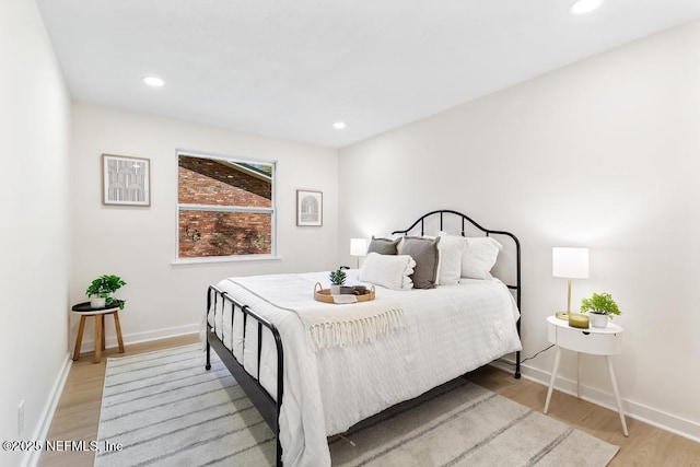 bedroom featuring baseboards, light wood finished floors, and recessed lighting