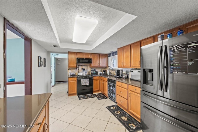 kitchen featuring light tile patterned flooring, visible vents, black appliances, dark countertops, and a raised ceiling