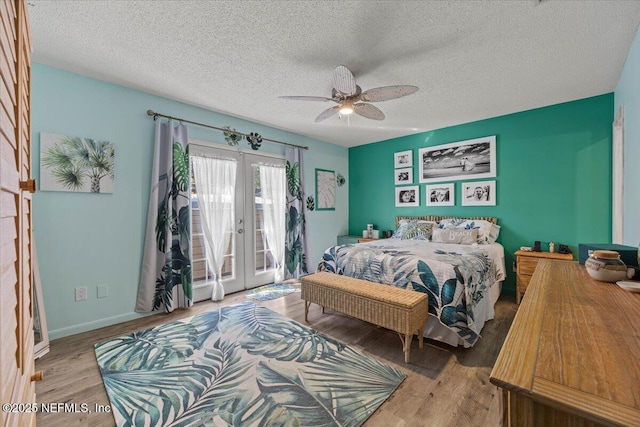 bedroom featuring access to exterior, french doors, a ceiling fan, wood finished floors, and baseboards