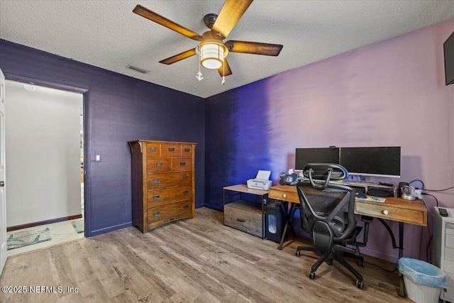 office featuring a ceiling fan, visible vents, a textured ceiling, and wood finished floors