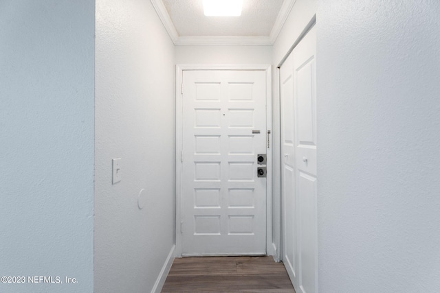 doorway featuring baseboards, ornamental molding, and dark wood-type flooring