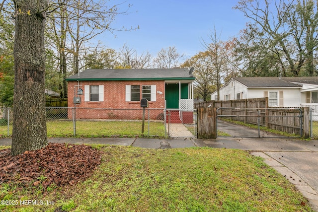 view of front of property with a fenced front yard, a front yard, a gate, and brick siding