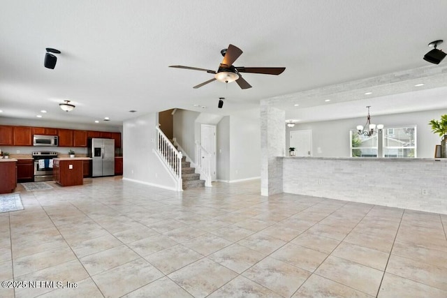 unfurnished living room featuring baseboards, ceiling fan with notable chandelier, stairway, and light tile patterned flooring