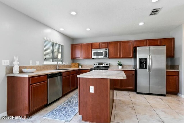 kitchen featuring a sink, visible vents, light countertops, appliances with stainless steel finishes, and a center island