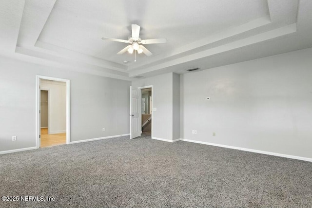 interior space with carpet, a raised ceiling, and visible vents