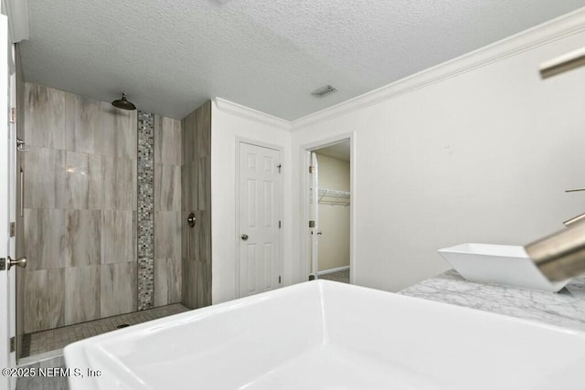 bedroom with ornamental molding, a closet, visible vents, and a textured ceiling