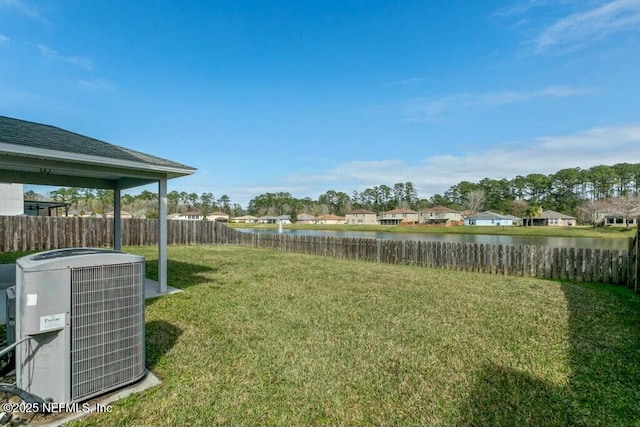 view of yard featuring a water view, cooling unit, a residential view, and fence