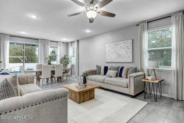 living area featuring baseboards, a ceiling fan, and recessed lighting