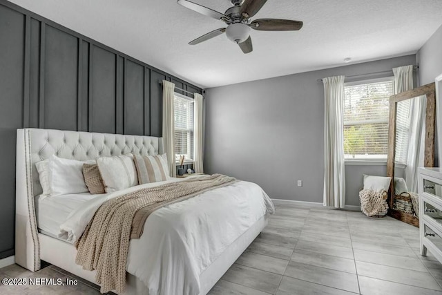 bedroom featuring baseboards, a ceiling fan, and light tile patterned flooring