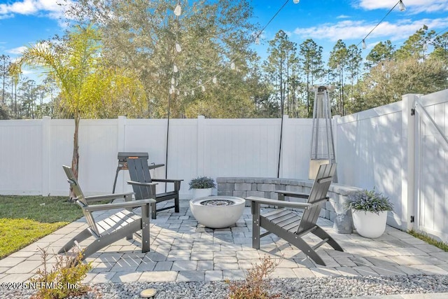 view of patio / terrace featuring an outdoor fire pit and a fenced backyard