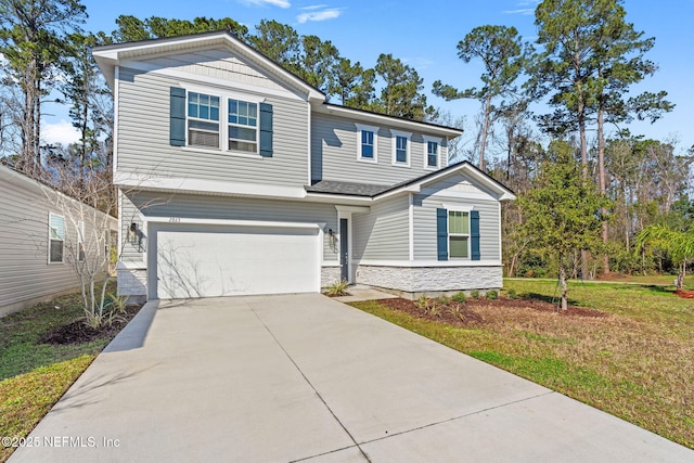 view of front of property with a front yard, stone siding, driveway, and an attached garage