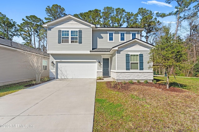 view of front of property featuring a garage, a front yard, concrete driveway, and stone siding