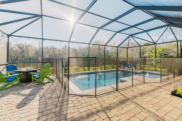 view of swimming pool with a fire pit, a patio area, a lanai, and a fenced in pool