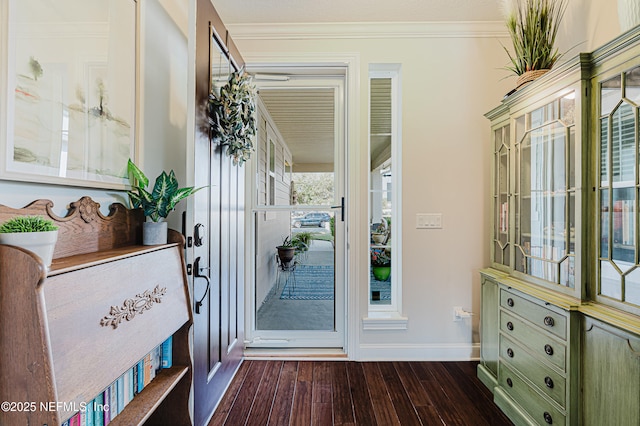 entrance foyer featuring crown molding, dark wood finished floors, and baseboards