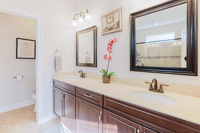 full bathroom featuring double vanity, tile patterned flooring, a sink, and toilet