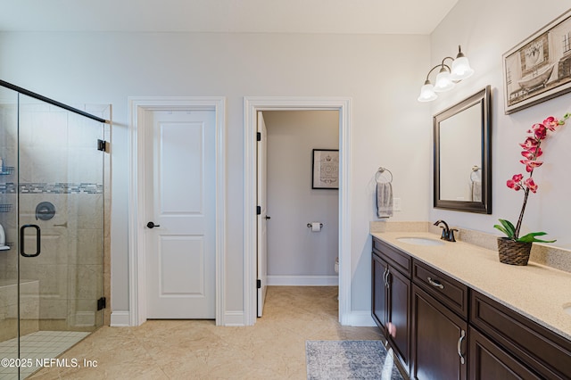 bathroom with double vanity, a shower stall, toilet, and a sink