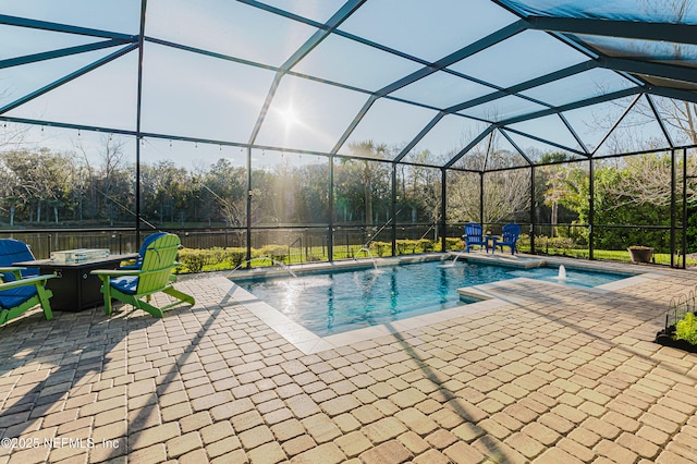 outdoor pool with a patio, an outdoor fire pit, and a lanai