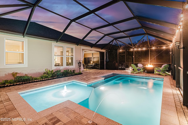 pool at dusk featuring an outdoor fire pit, a lanai, and a patio